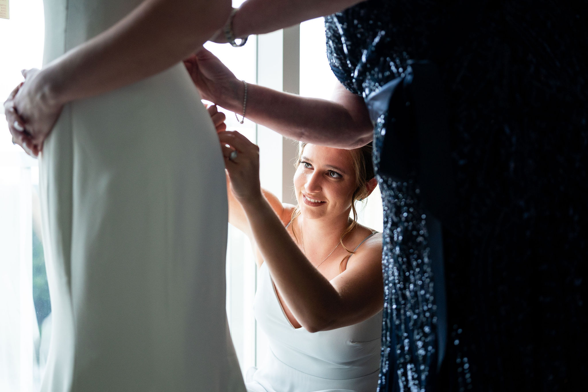 maid of honor helping bride with dress