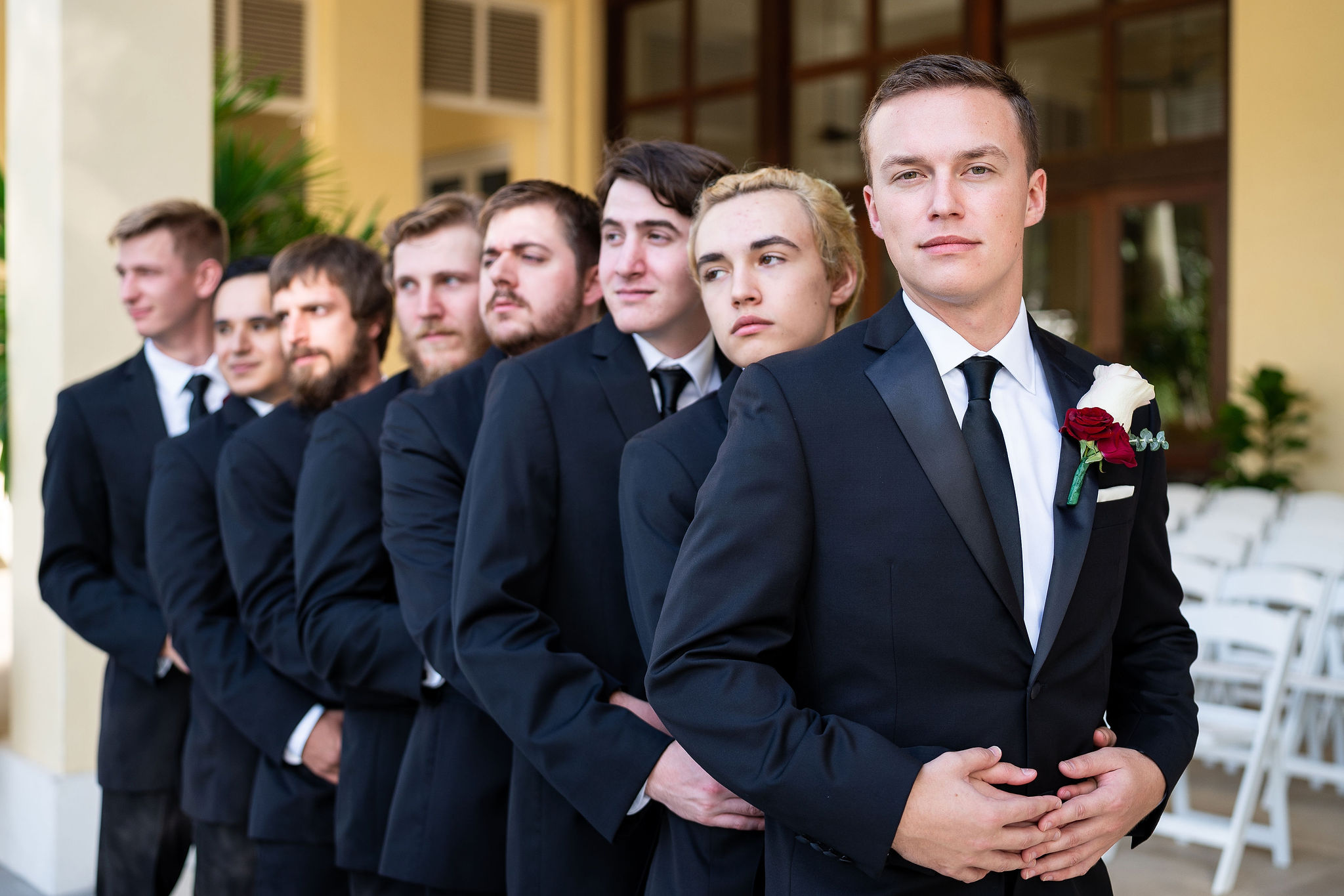 groom and groomsmen posing in front of venue in naples florida