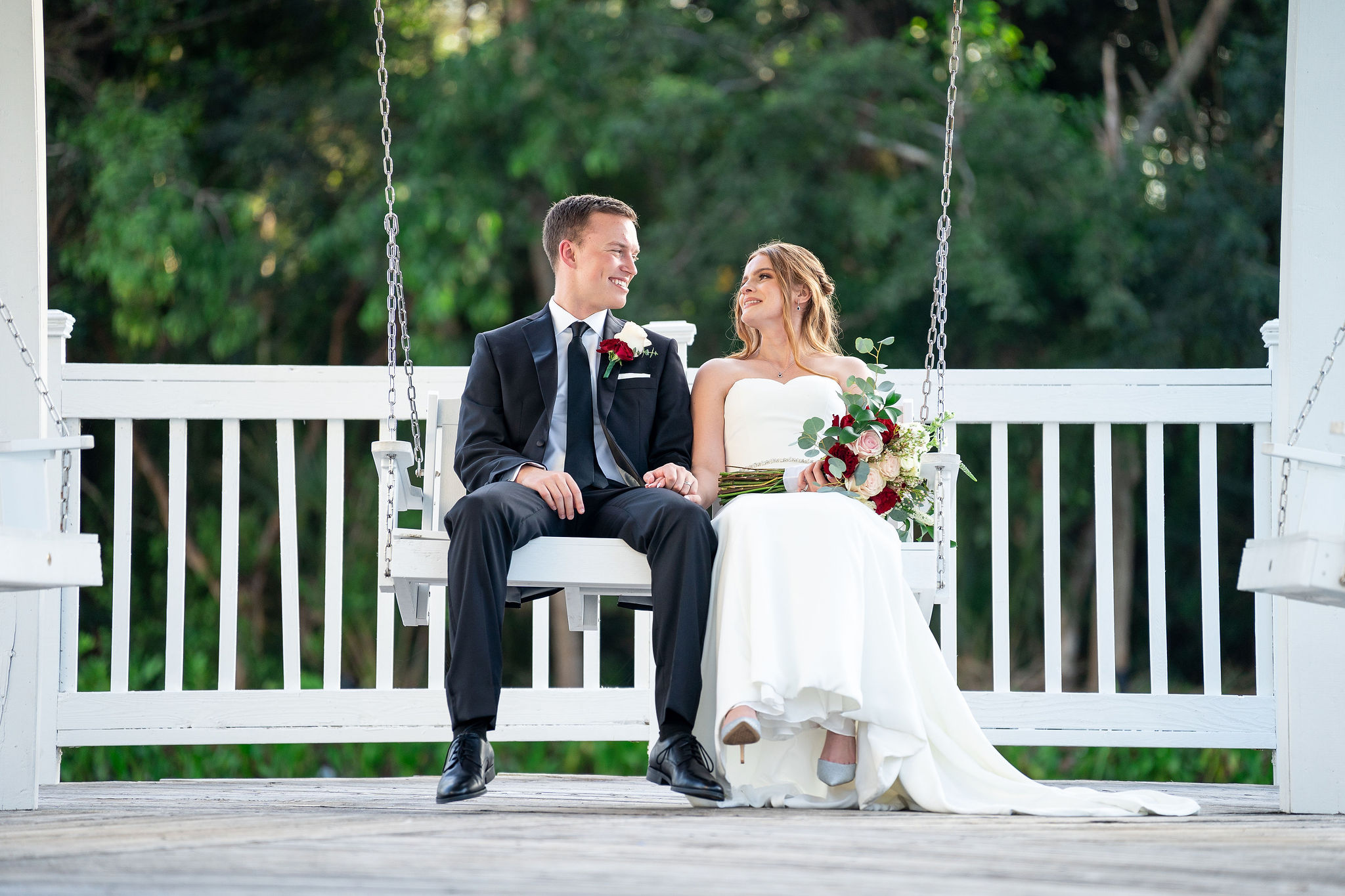 bride and groom swinging on a bench