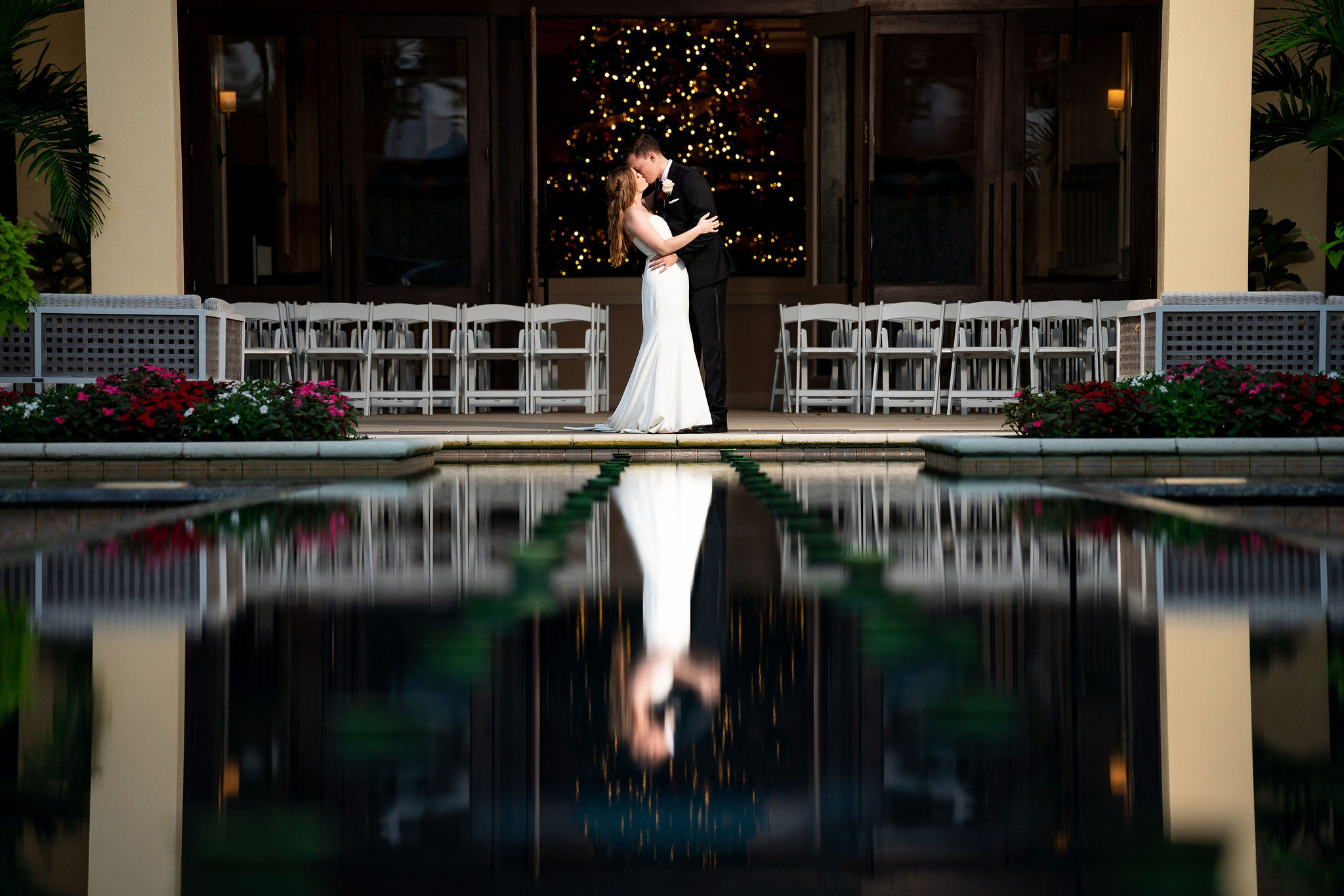 bride and groom portrait with their reflection in a fountain during their naples florida wedding