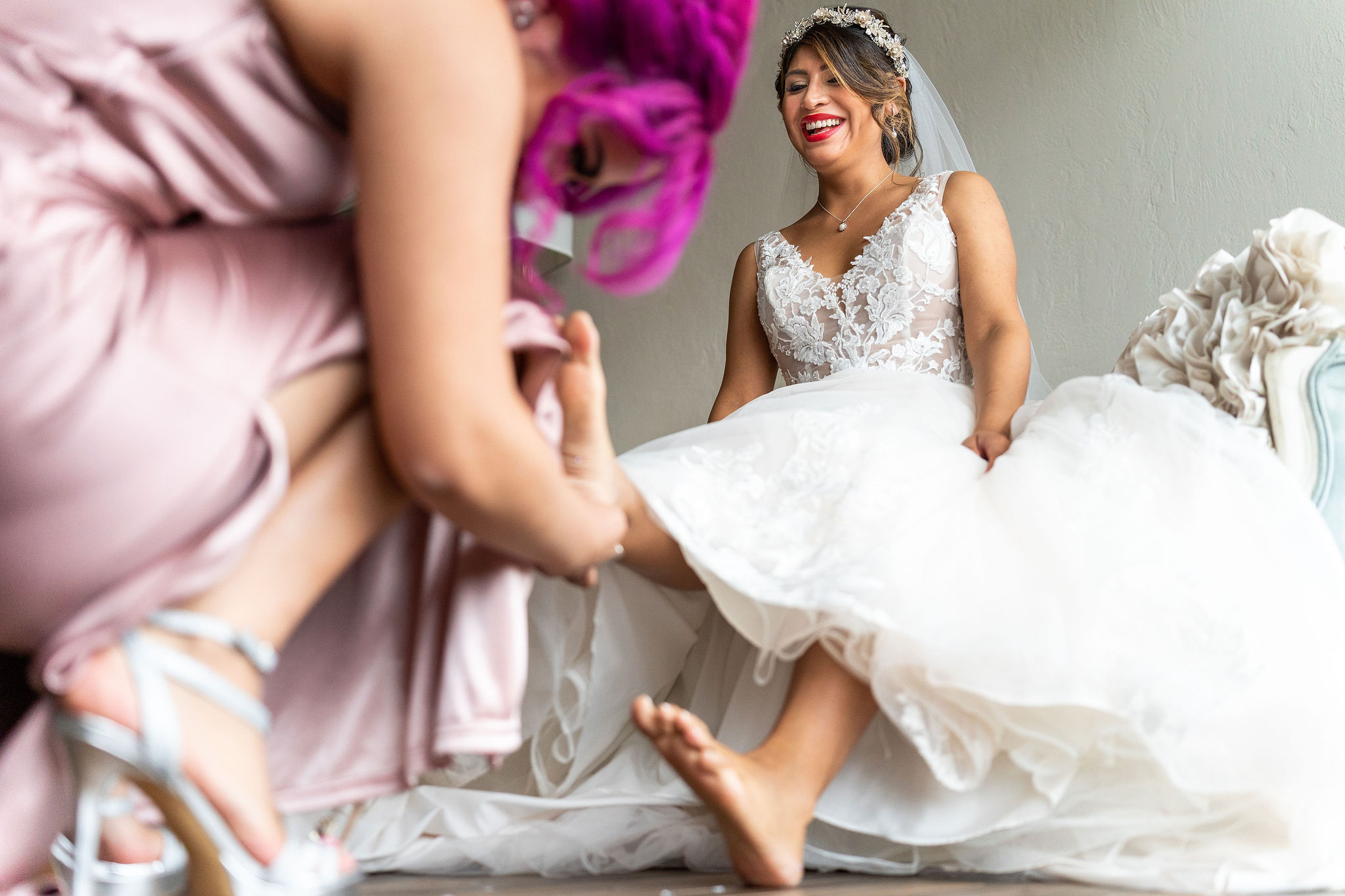 maid of honor helping bride get her shoes on