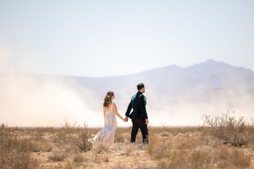 bride and groom walking in the desert