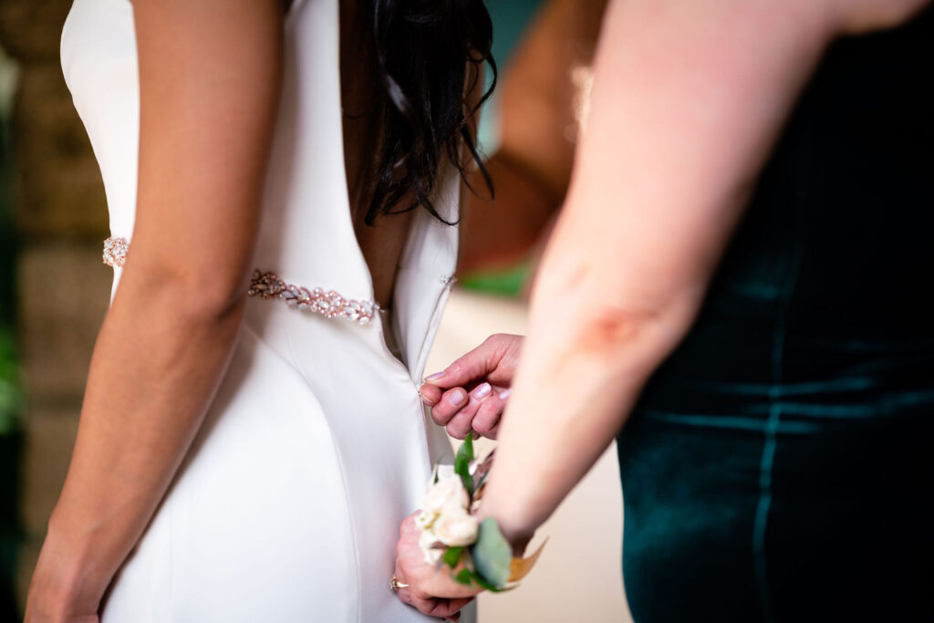zipping up the brides dress